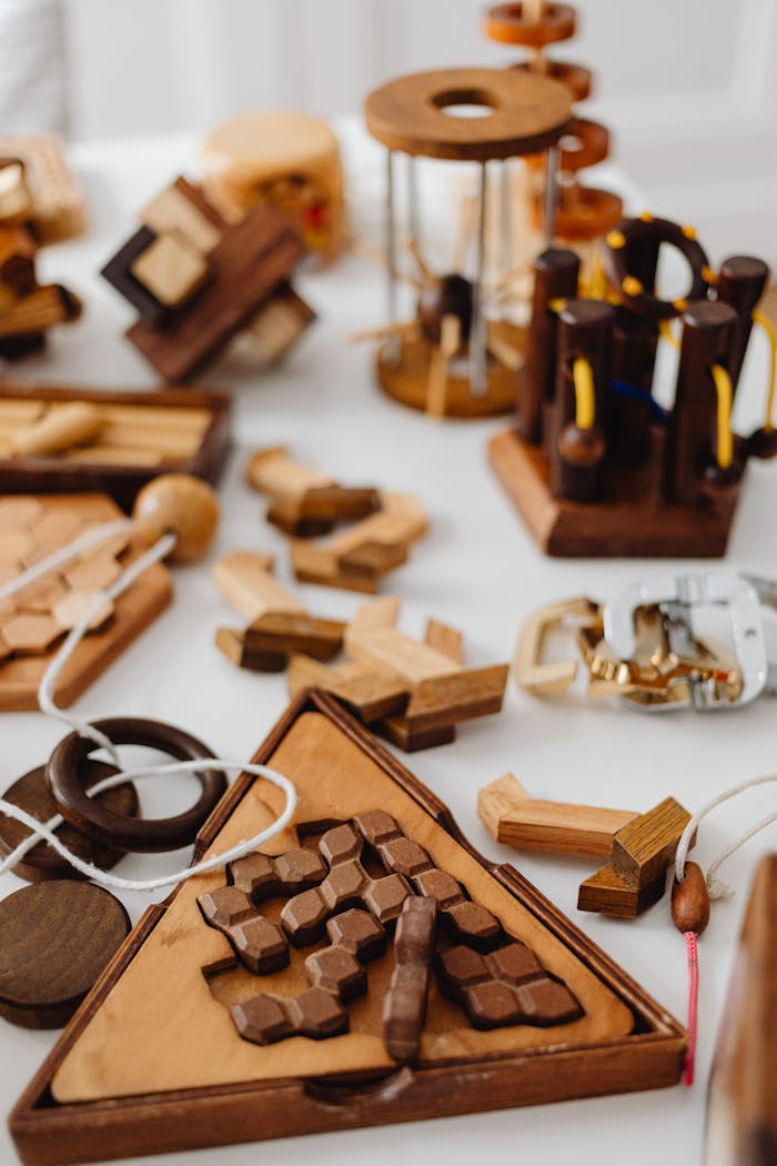 A variety of wooden brain teasers and puzzles on a white tabletop.
